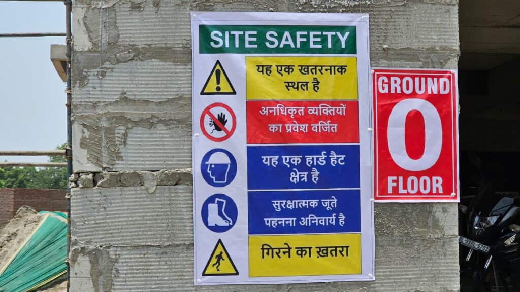 Site safety signage with Hindi safety instructions at an under-construction building